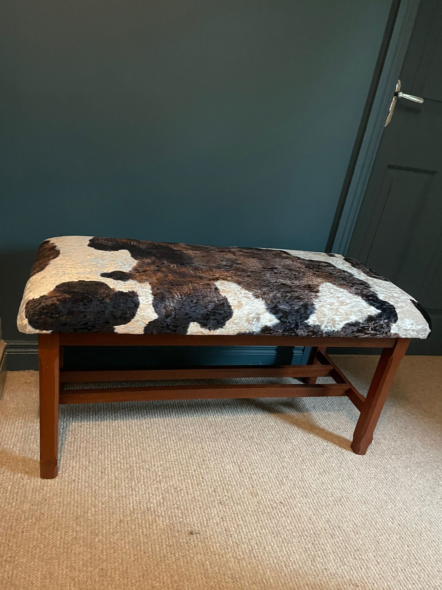 A Large Window Stool with Cowhide Style Upholstery.