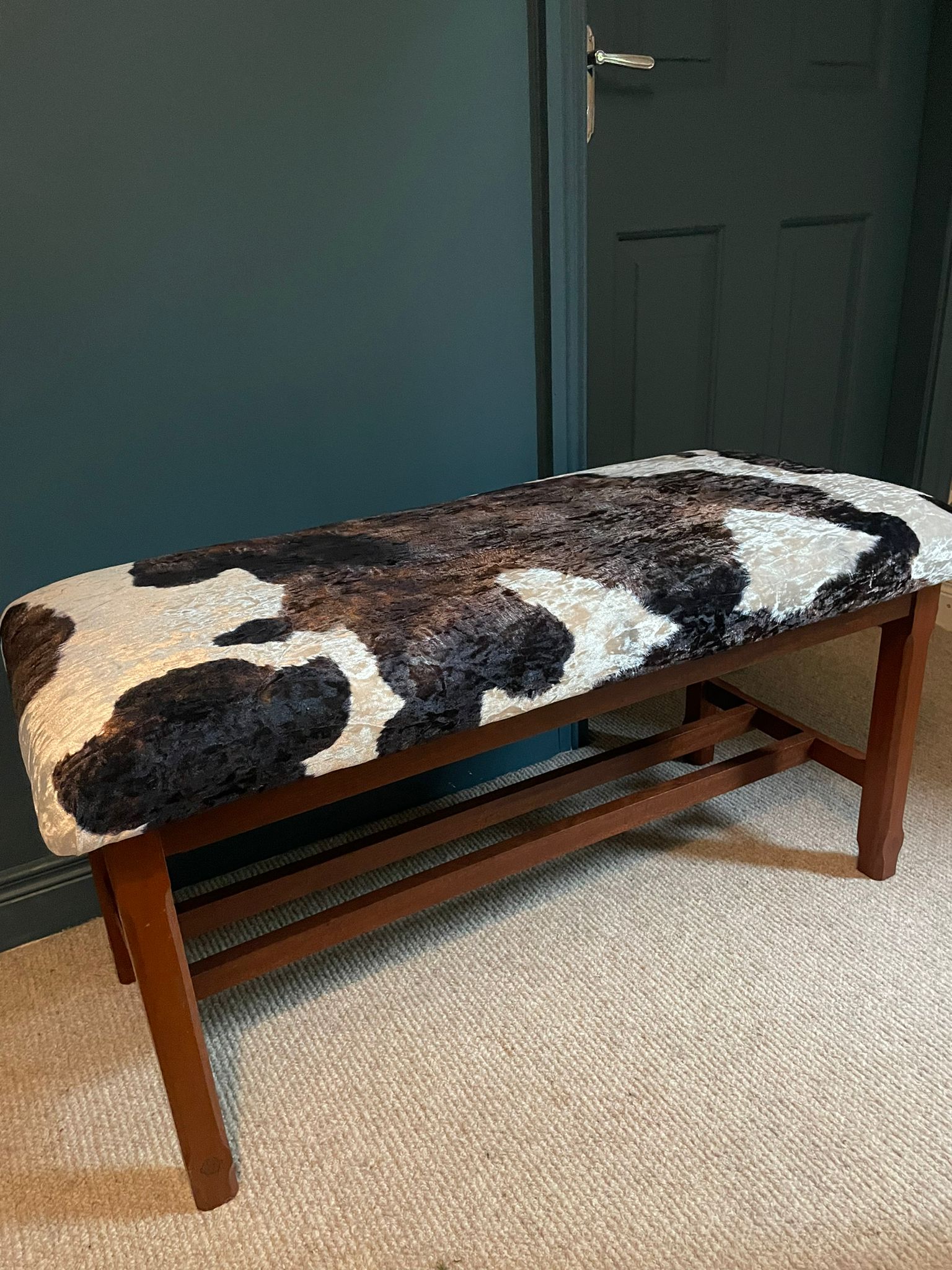 A Large Window Stool with Cowhide Style Upholstery.